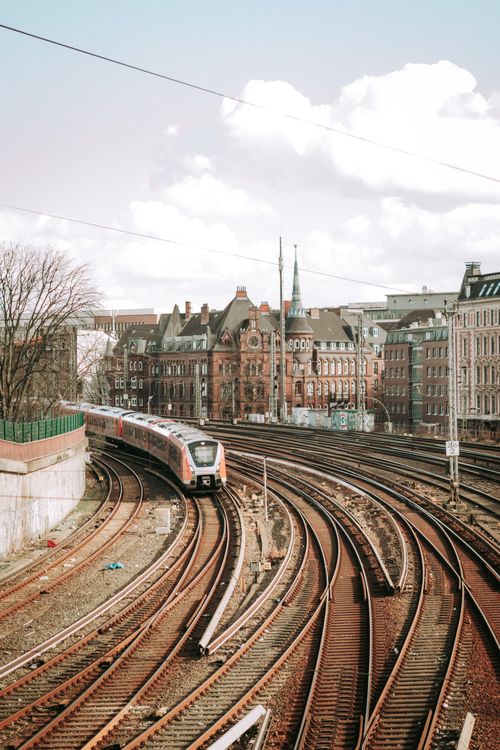Free Train navigating through historic architecture in Hamburg, capturing urban transit vibes. Stock Photo