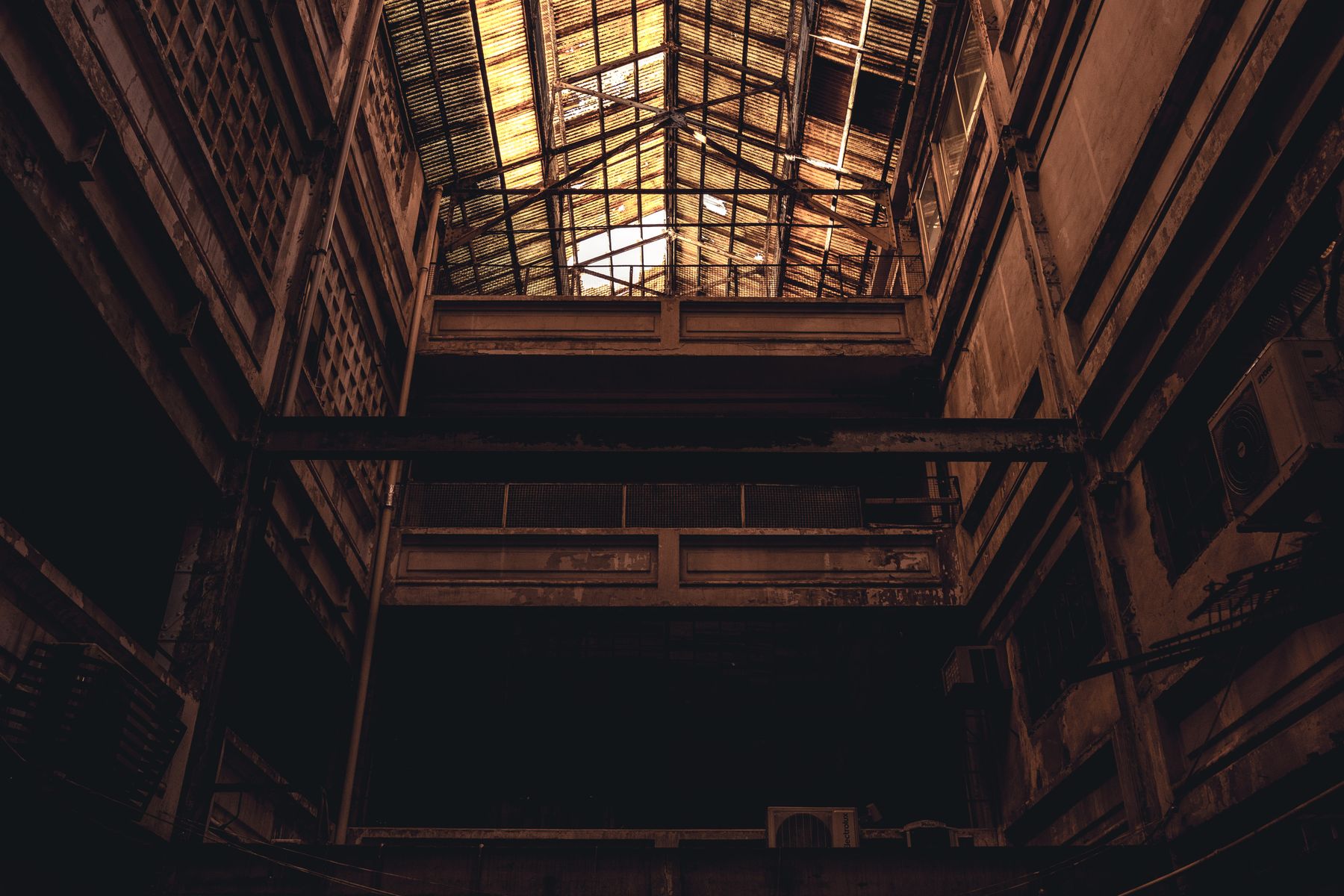 Glazed roof of an old industrial hall lit from above — Athena Sandrini on Pexels