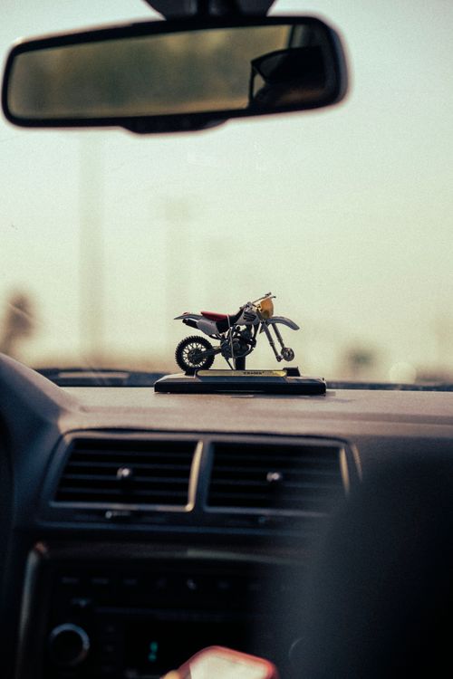 Free Motorcycle figurine decor on car dashboard, artistic shot. Stock Photo