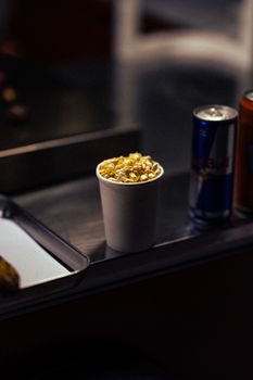 Close-up of popcorn and an energy drink can on a counter in Dubai, capturing a casual snack moment.