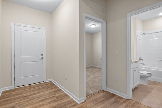 Bright and spacious apartment hallway leading to a bathroom and a room.