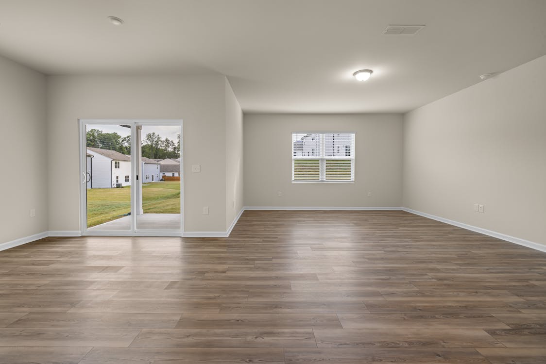 Free Bright and spacious minimalist living room interior with wooden flooring and garden view. Stock Photo