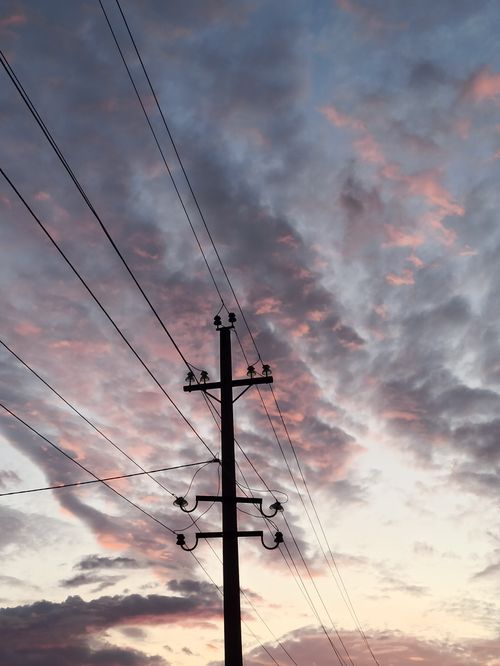 Free Power lines silhouetted against a vibrant sunrise in Kazakhstan. Stock Photo