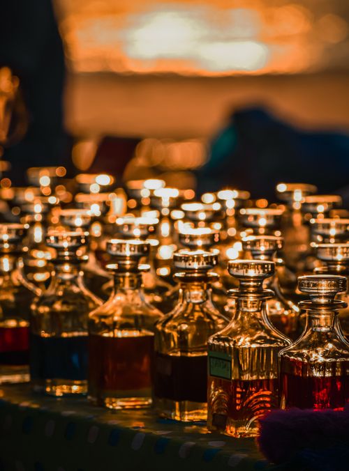 Free Close-up of luminous glass bottles in a dimly lit bar, creating a moody nightlife ambiance. Stock Photo