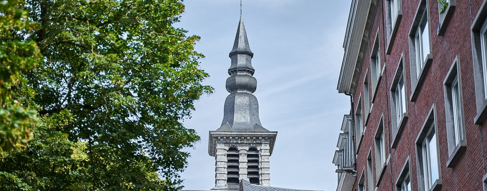 Stunning view of Saint Jean-Baptiste Church tower surrounded by urban architecture in Namur, Belgium.