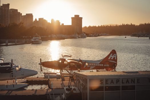 Beautiful sunset view of seaplanes at Vancouver Harbour with city skyline in the background.