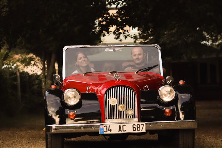 Man And Woman Driving In A Vintage Car