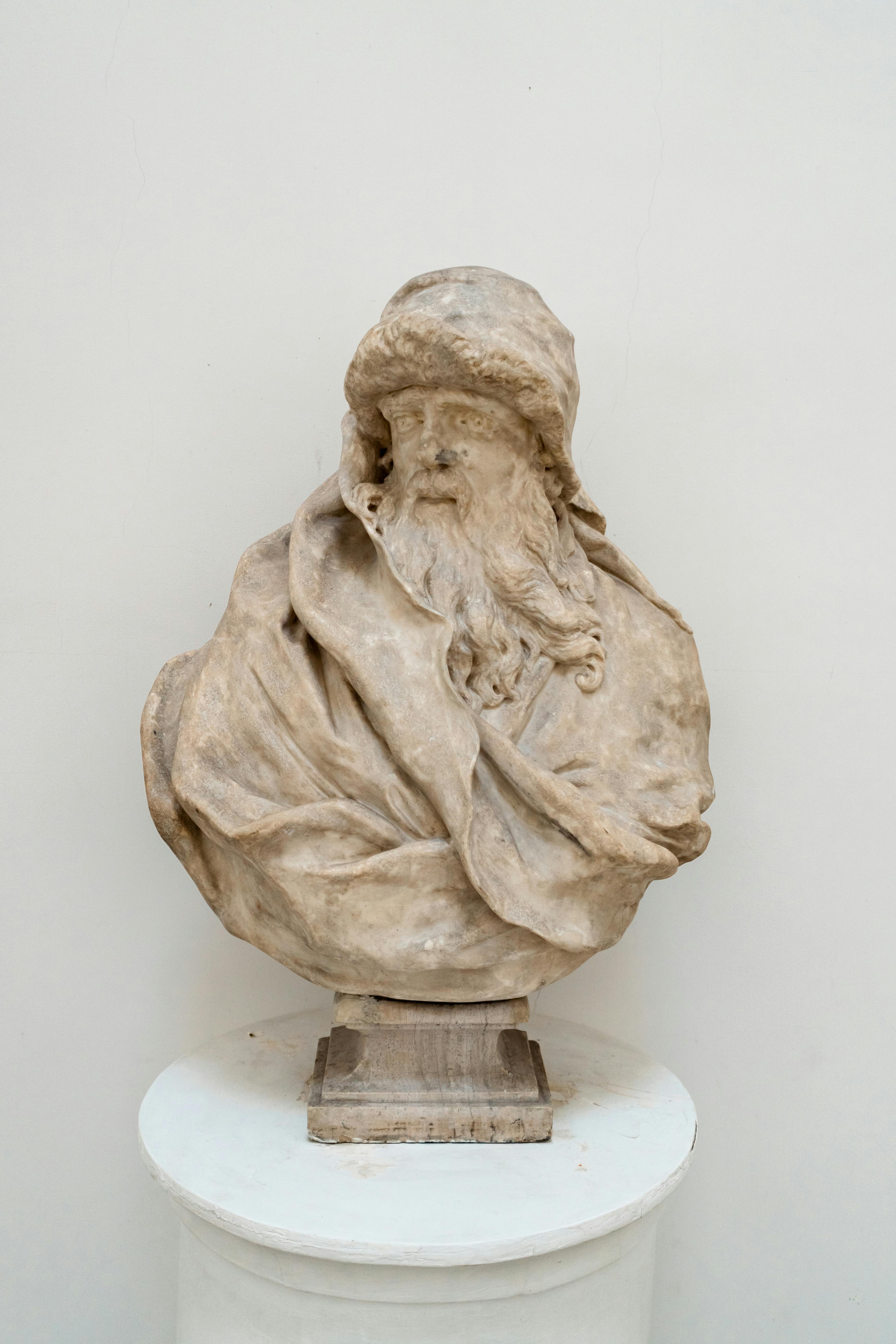A detailed marble bust depicting a bearded man, showcasing classical artistry and intricate detailing.