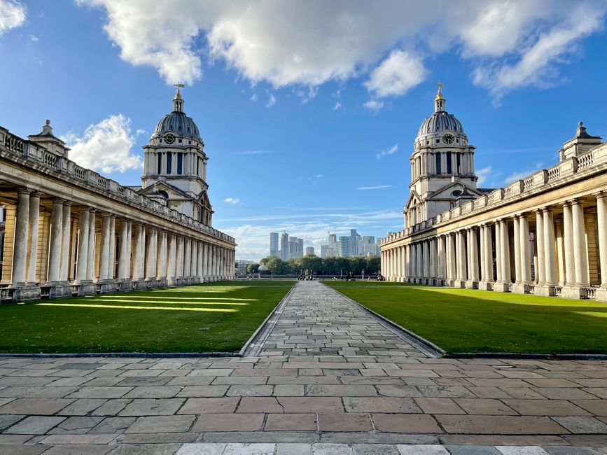 View of the Old Royal Naval College with city skyline in Greenwich, London.