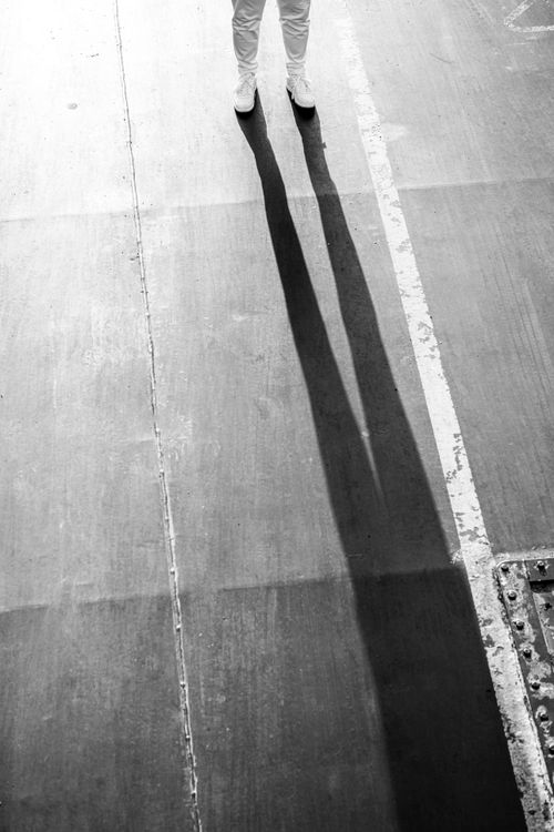 Free Black and white image of long shadows cast on a deck, creating a striking abstract pattern. Stock Photo