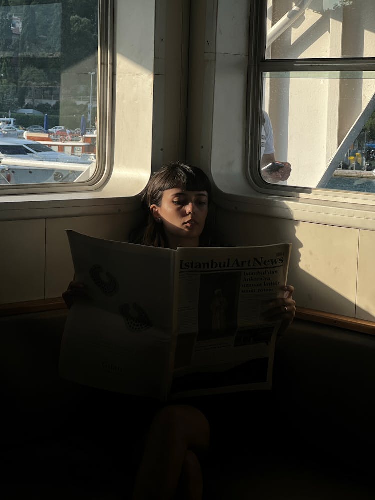 Woman Reading Newspaper On Ferry