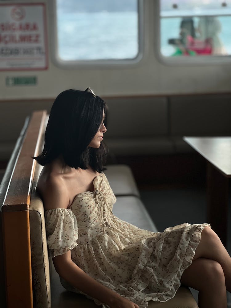 Woman In Floral Sundress Sitting On Ferry Bench