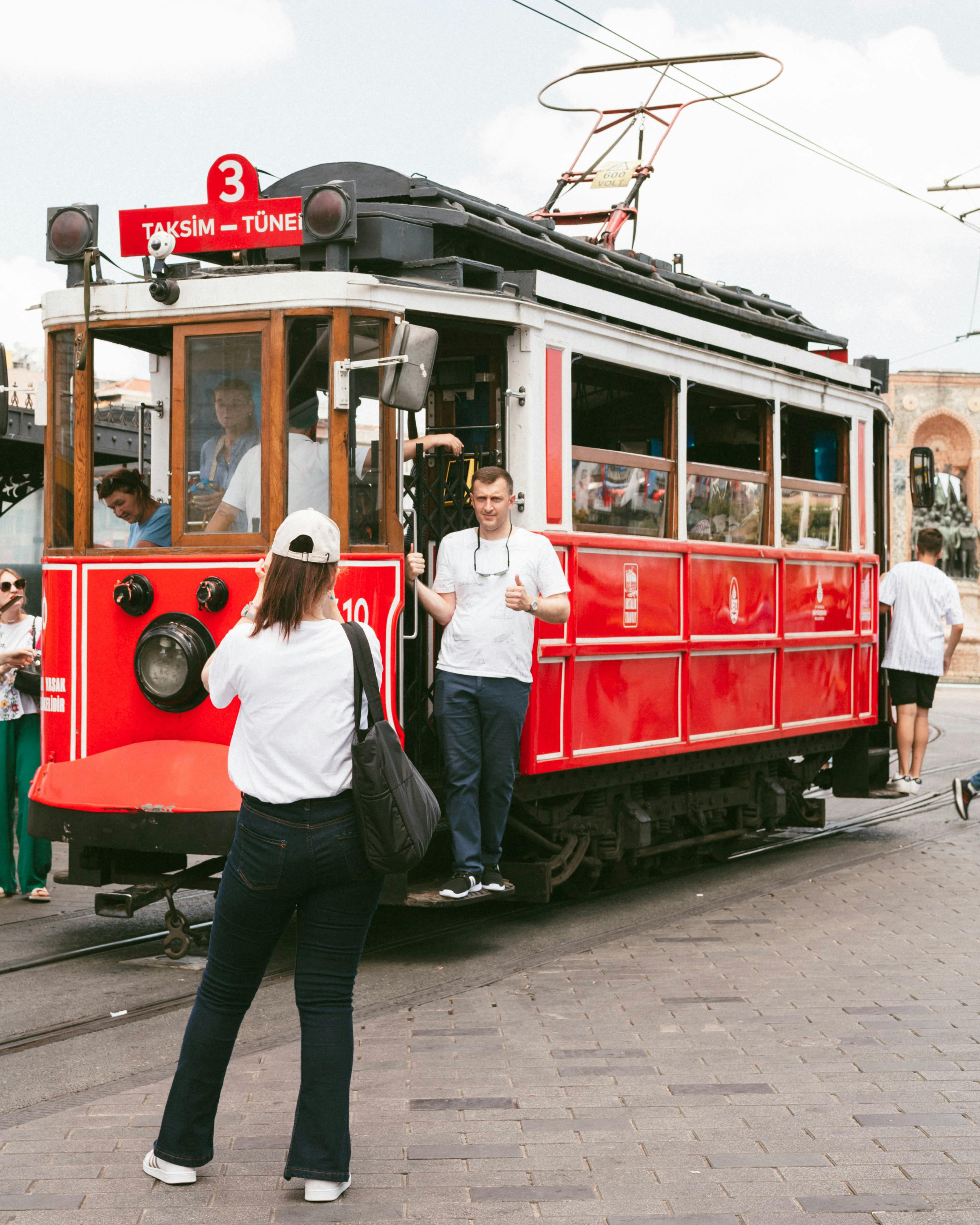 Vintage red tram in Taksim Square, Istanbul, Türkiye, capturing urban life and bustling atmosphere.