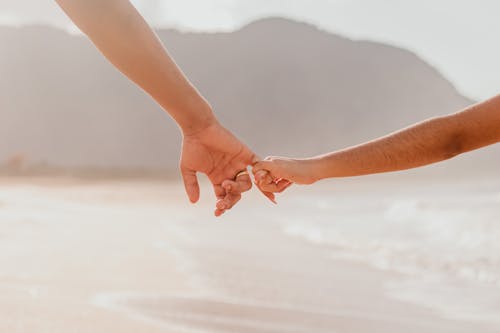 Couple Holding Hands on Sea Shore