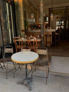 Cozy urban café with outdoor tables and elegant interior design.
