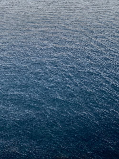 Free Serene aerial view of ocean water with gentle ripples creating a tranquil texture. Stock Photo