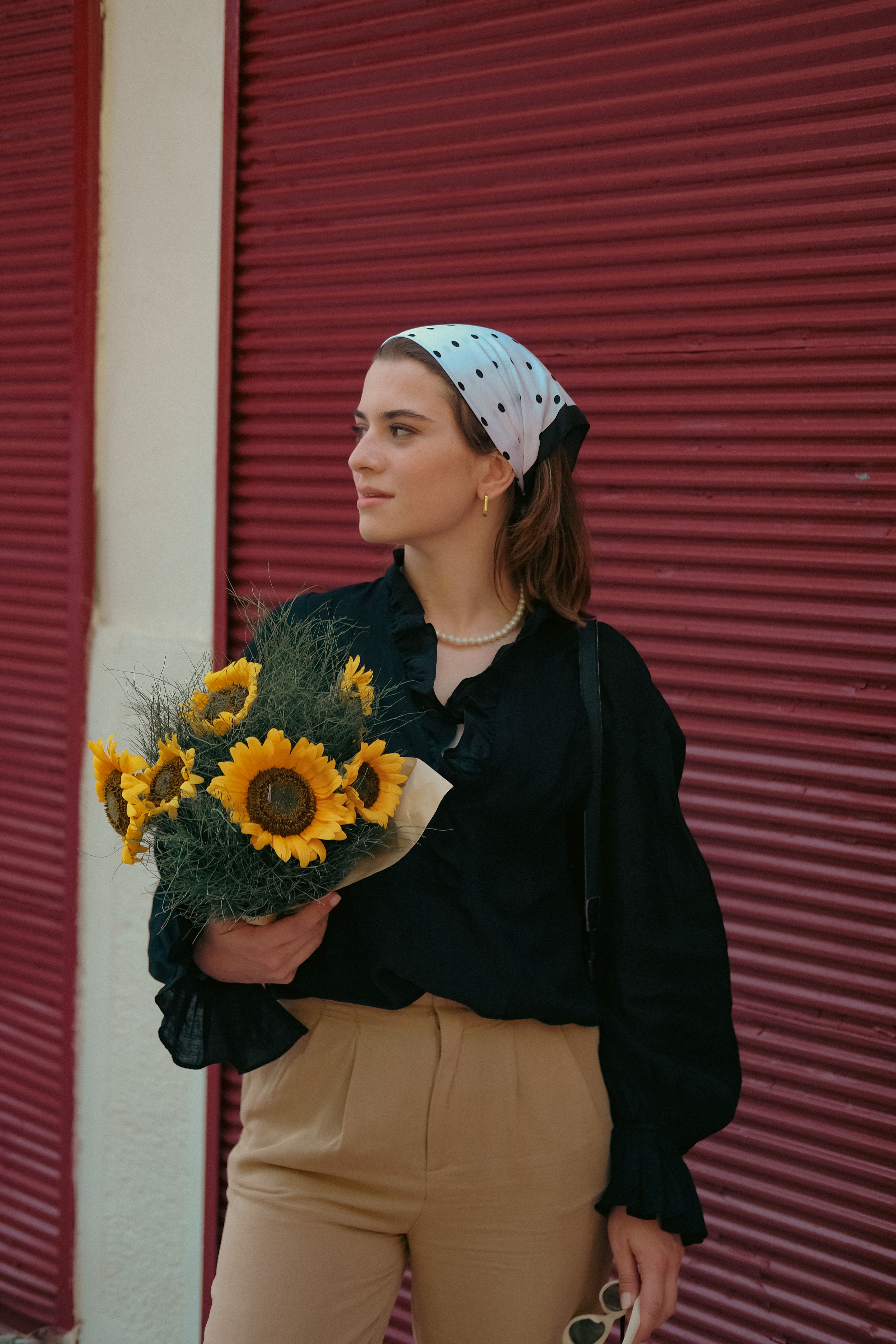 Young Woman Standing Outside and Holding a Bouquet of Sunflowers · Free ...