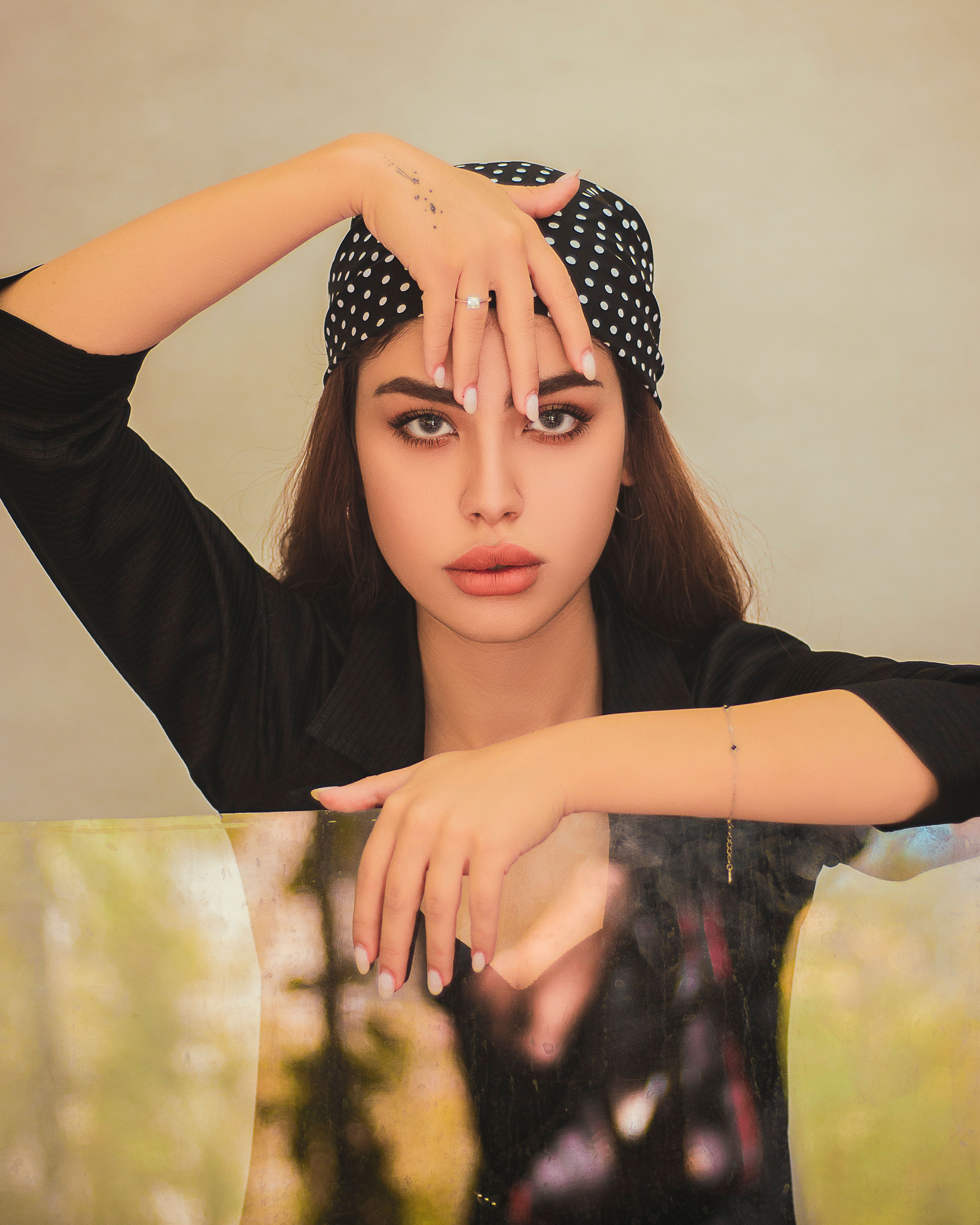 Elegant portrait of a woman wearing a black headscarf and shirt, exuding fashion and modern style.