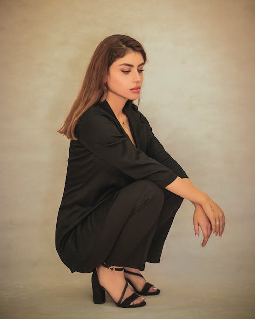 Woman Squatting in Black Suit