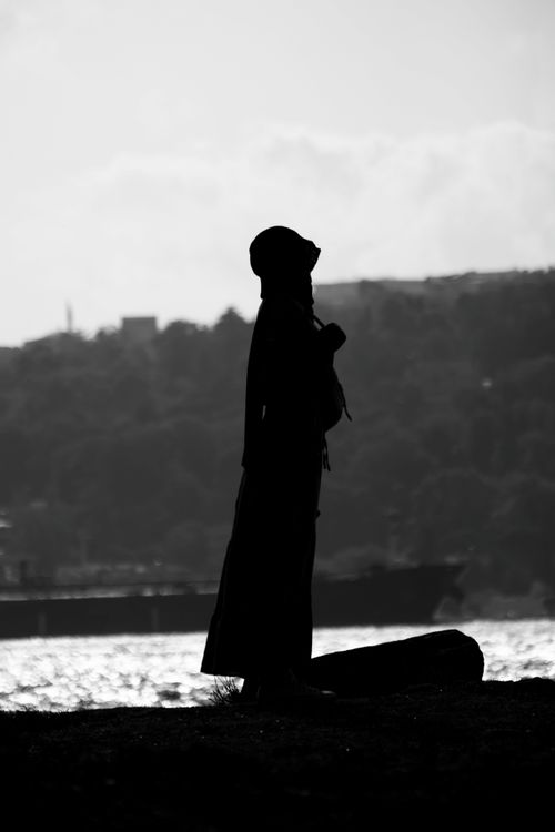 Free Captivating black and white silhouette of a person standing by the seaside. Stock Photo