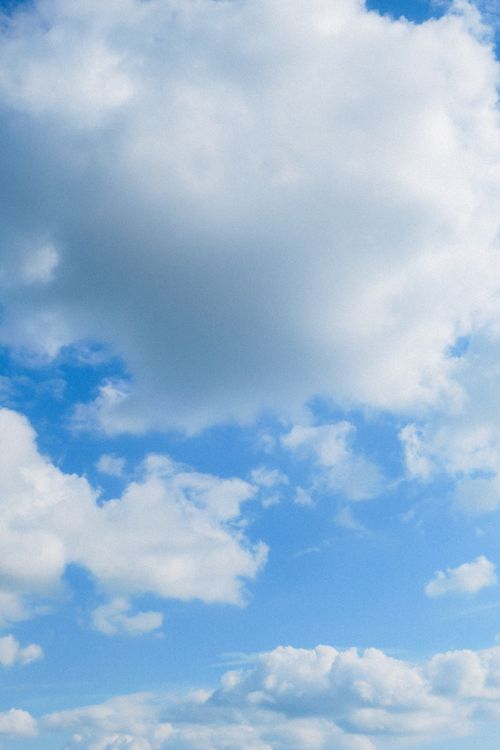 Free Serene view of a blue sky filled with fluffy white clouds on a clear day. Stock Photo