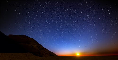 Beautiful landscape of a sunset and sky and stars at night with sand Mountain