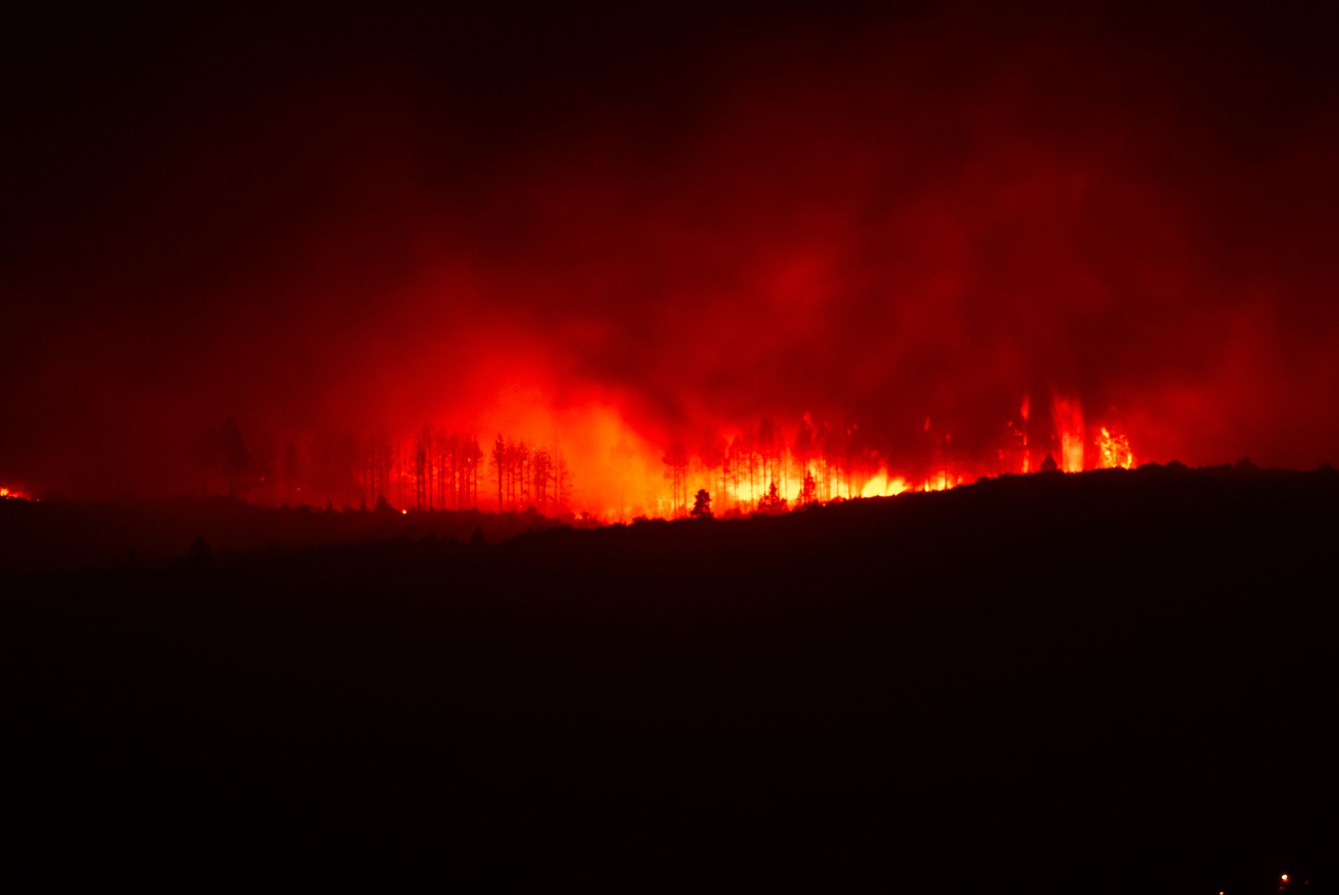 Épaisse fumée d'incendie s'élevant sous un ciel orangé