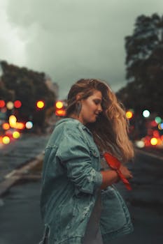 黄昏时分，一位身穿牛仔夹克的时尚女子在城市街道上微笑，散景灯光照亮了四周