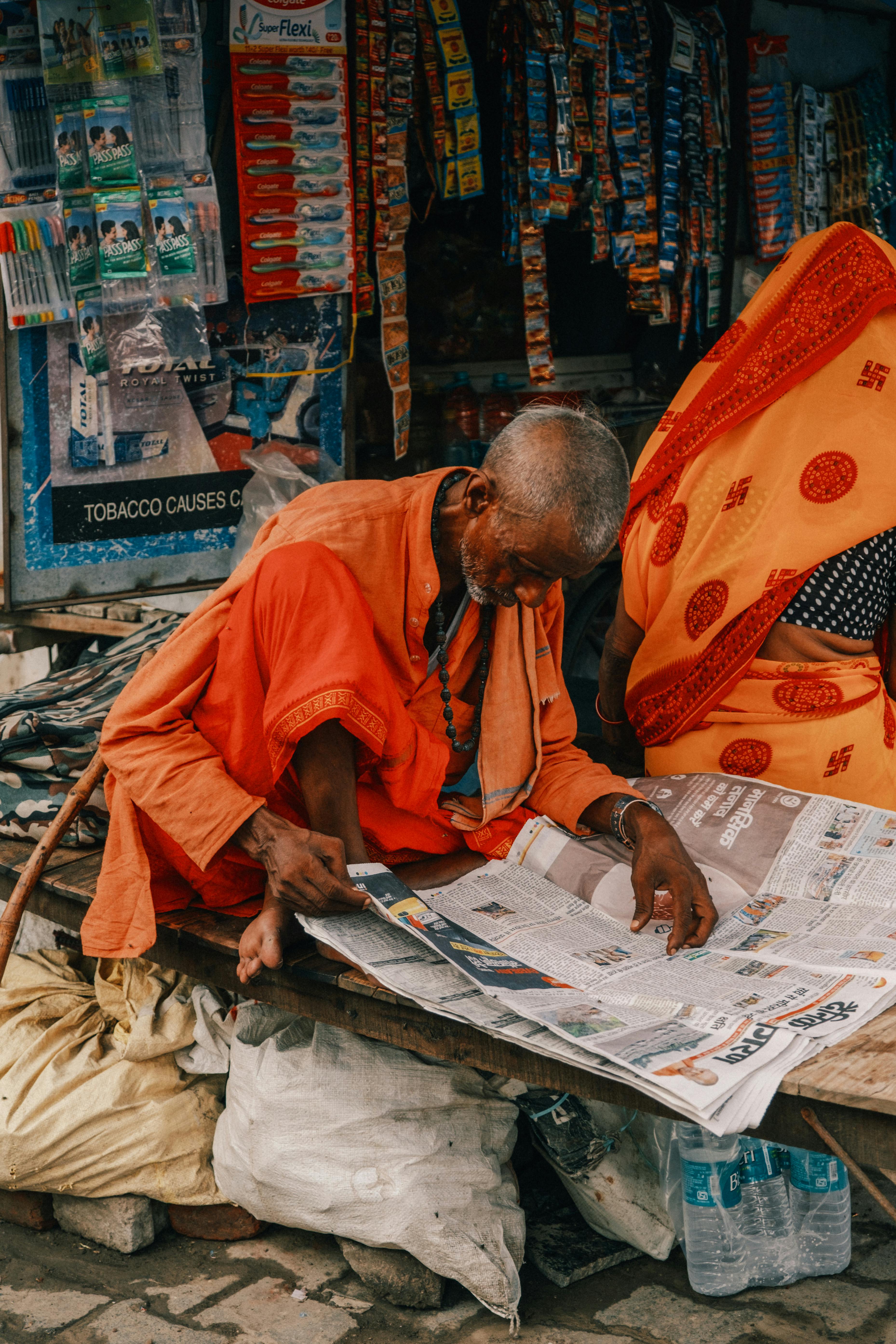 Indian Man in Traditional Religious Clothing Reading a Newspaper · Free