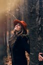 树林里，一位优雅的女人戴着橙色帽子，拥抱秋天