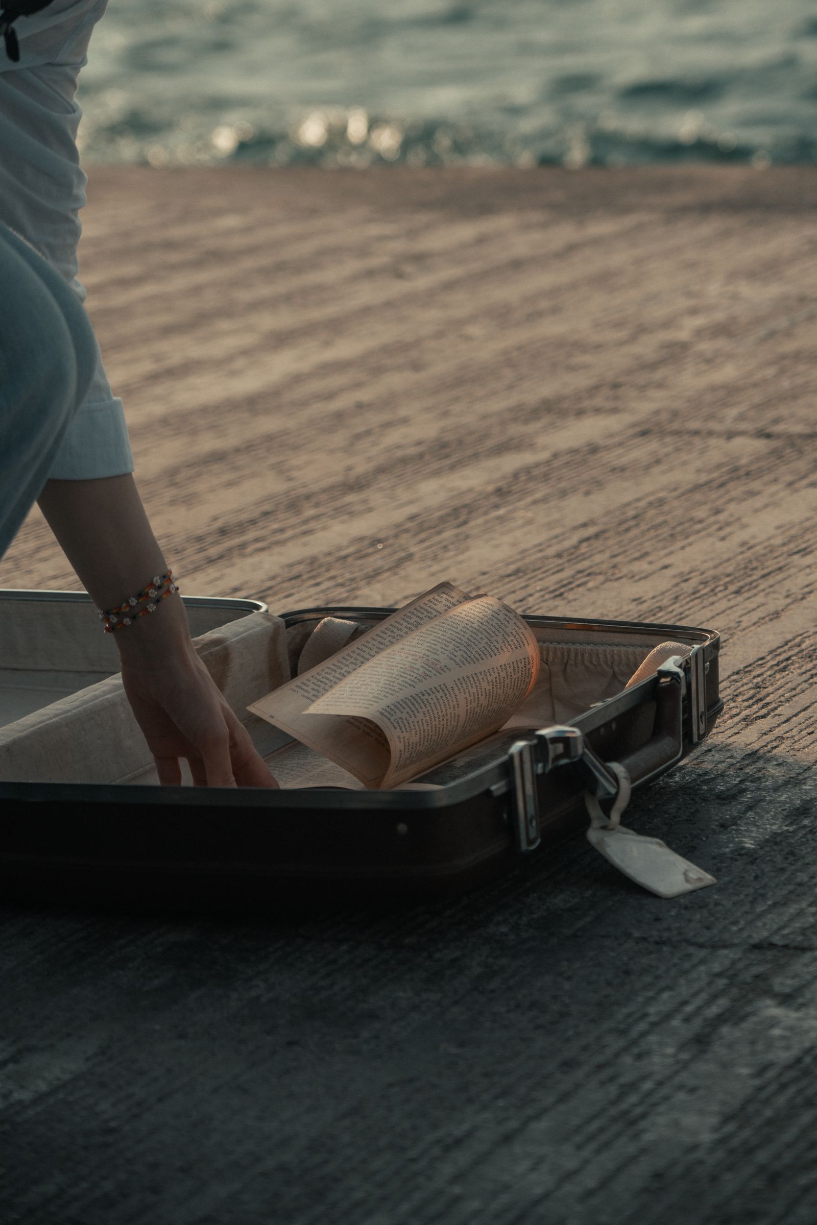 Open suitcase on a boardwalk, packing for a stay in someone else’s home
