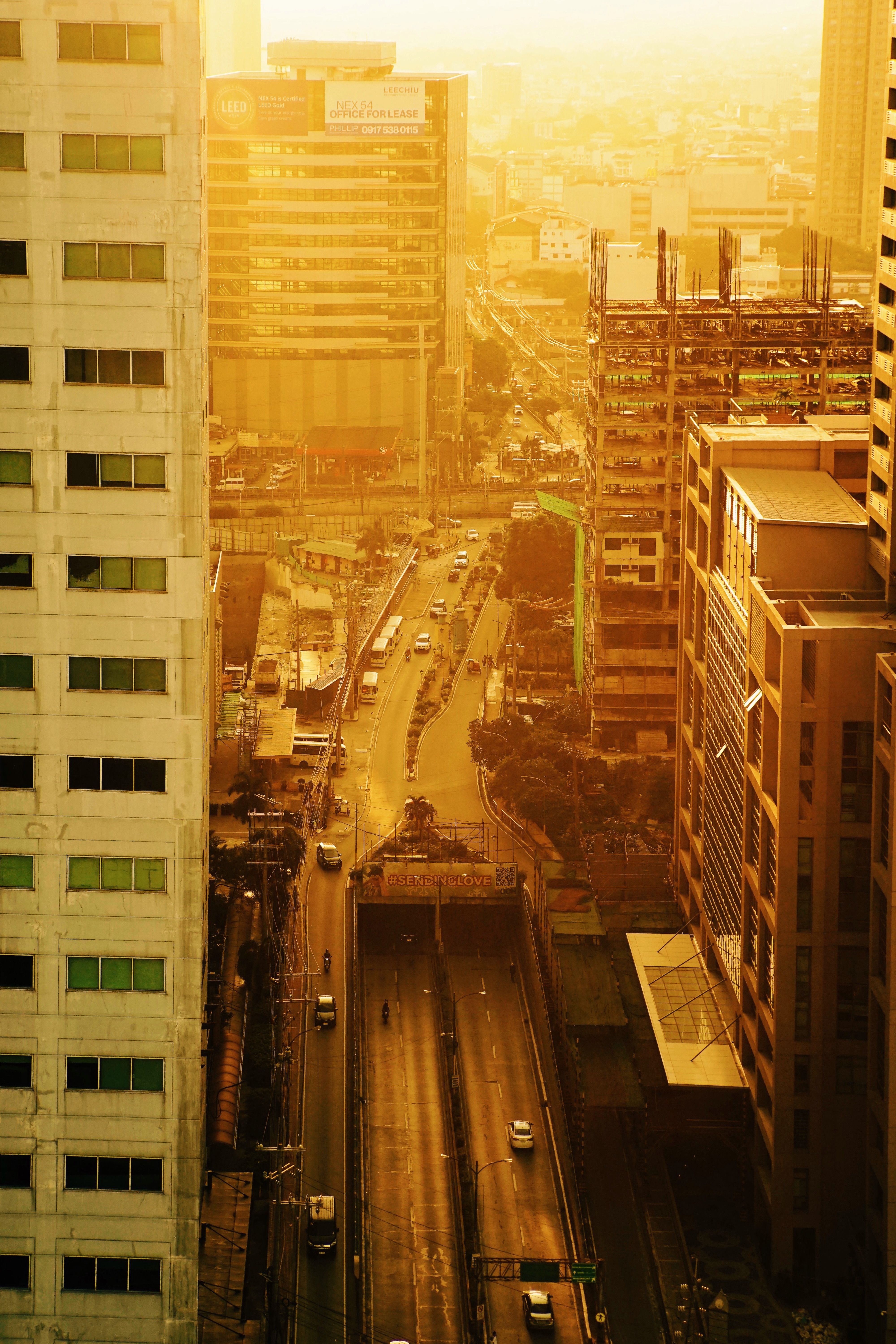 Sunset view of a bustling modern city with skyscrapers and busy streets.