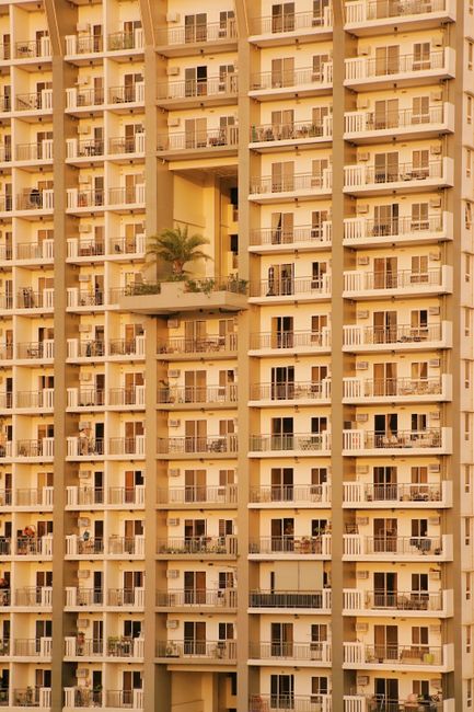 Close-up of a contemporary apartment building facade at sunset, showcasing modern urban architecture.