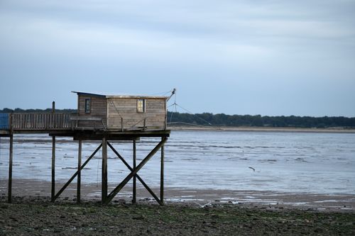 Free Wooden hut on stilts over a serene beach in La Rochelle, capturing coastal tranquility. Stock Photo
