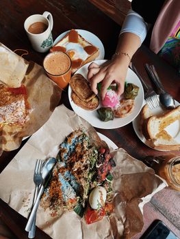 Top view of a traditional Malaysian breakfast spread with various local delicacies and drinks in a café.
