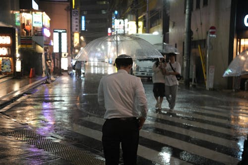 Man Walking with Transparent Umbrella at Night