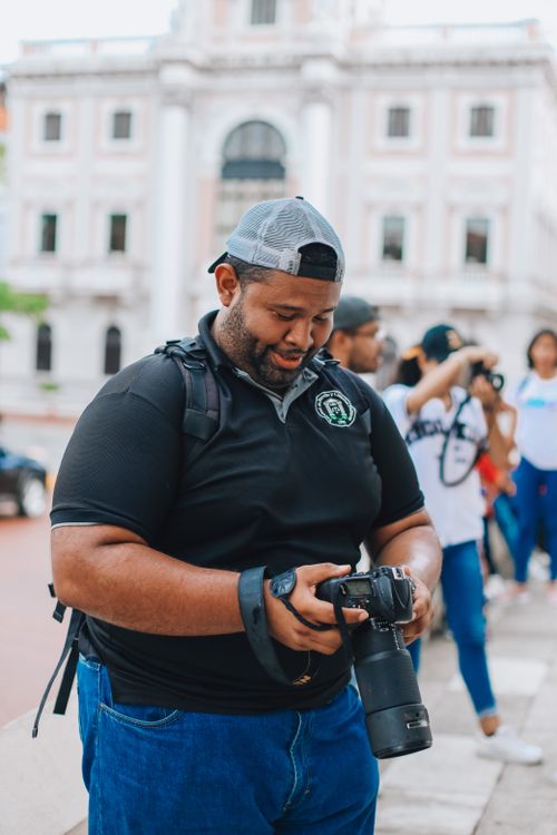 Free Man in casual attire checks camera settings outdoors in Panamá city. Stock Photo