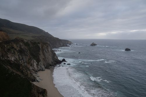Free A scenic view of rocky cliffs meeting the turbulent sea under an overcast sky. Stock Photo