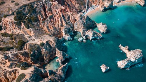 Free A breathtaking aerial view of the rocky Algarve coastline with turquoise waters and sandy beach. Stock Photo
