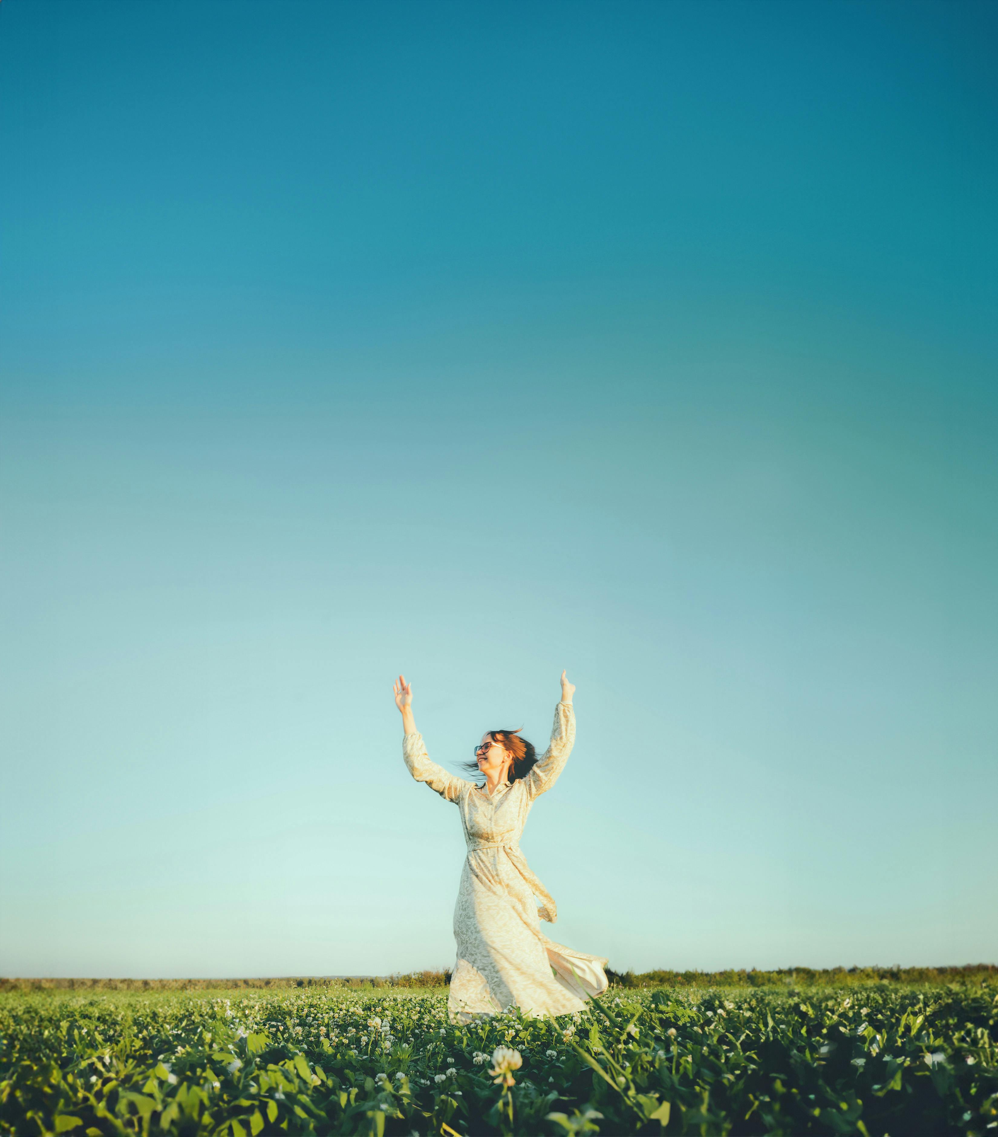 a young girl twirling at sunset in a field