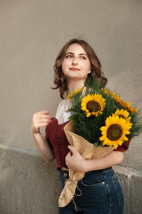 Portrait of Woman Standing with Bouquet of Sunflowers