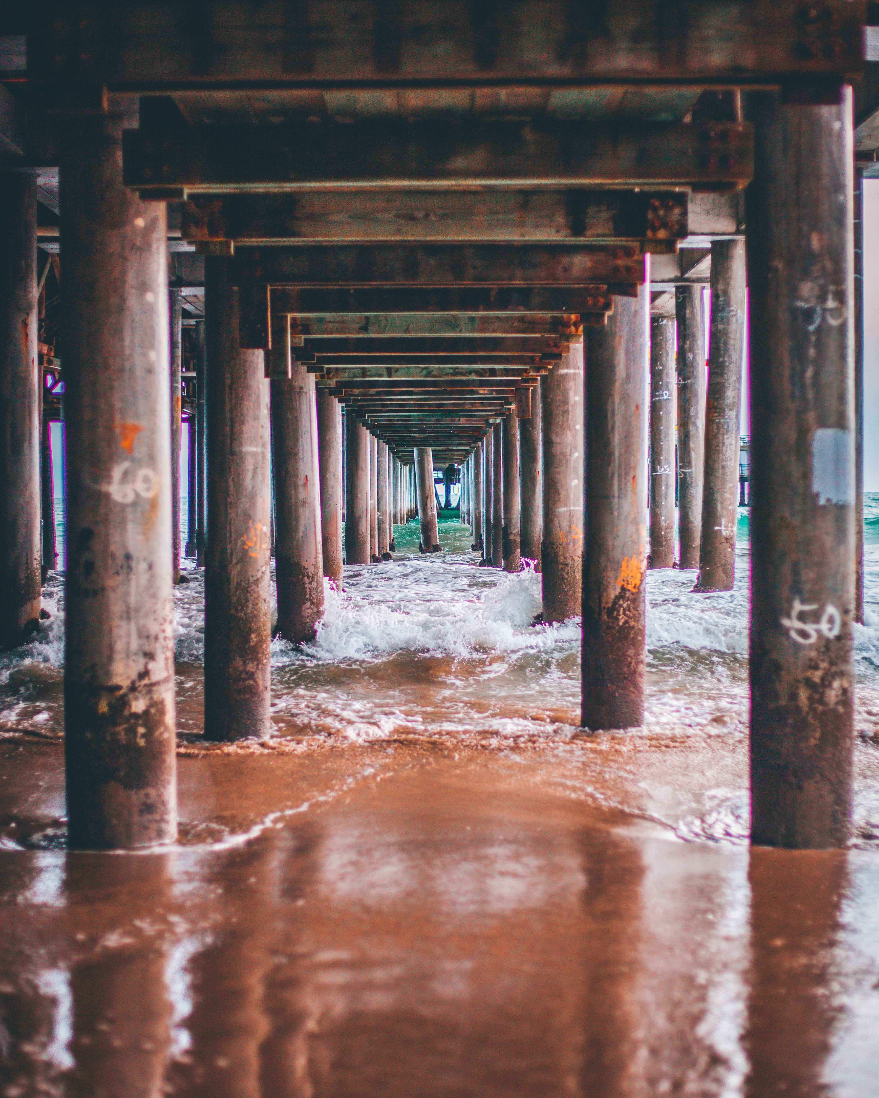从码头下方望去，汹涌的海浪和饱经风霜的柱子映入眼帘