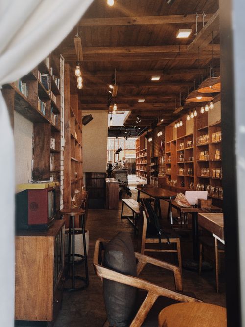 Free A warm and inviting café with rustic wooden furniture and shelves. Stock Photo