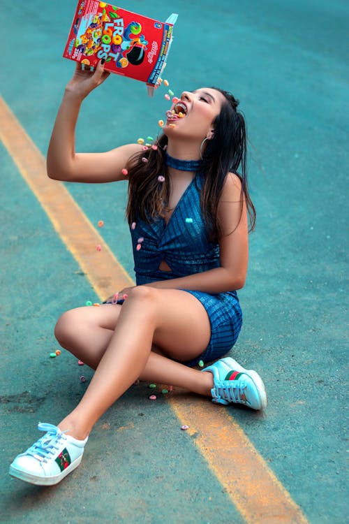 Free Woman Sitting on the Road Eating Froot Loops Stock Photo