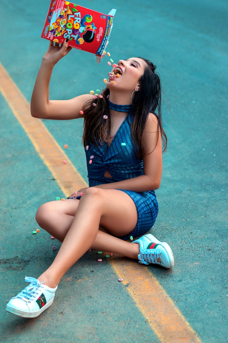 Woman Sitting On The Road Eating Froot Loops