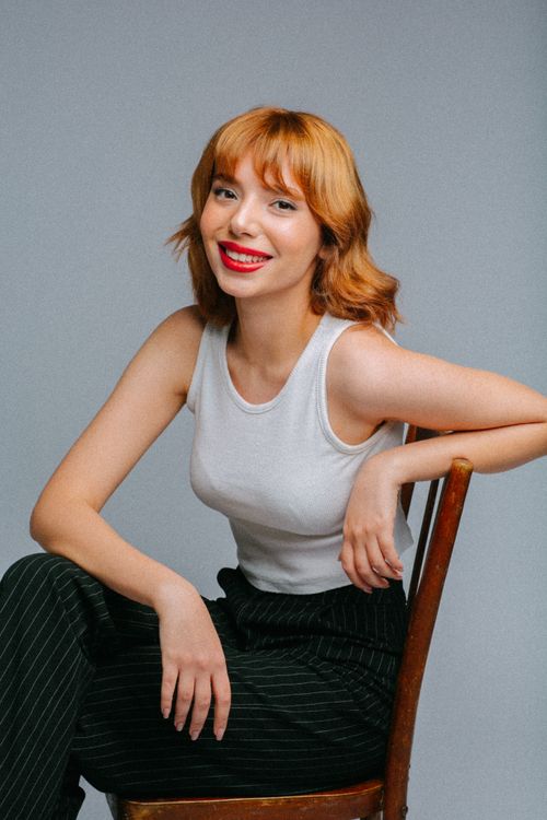 Studio Shot of a Young Woman sitting on a Chair and Smiling · Free ...