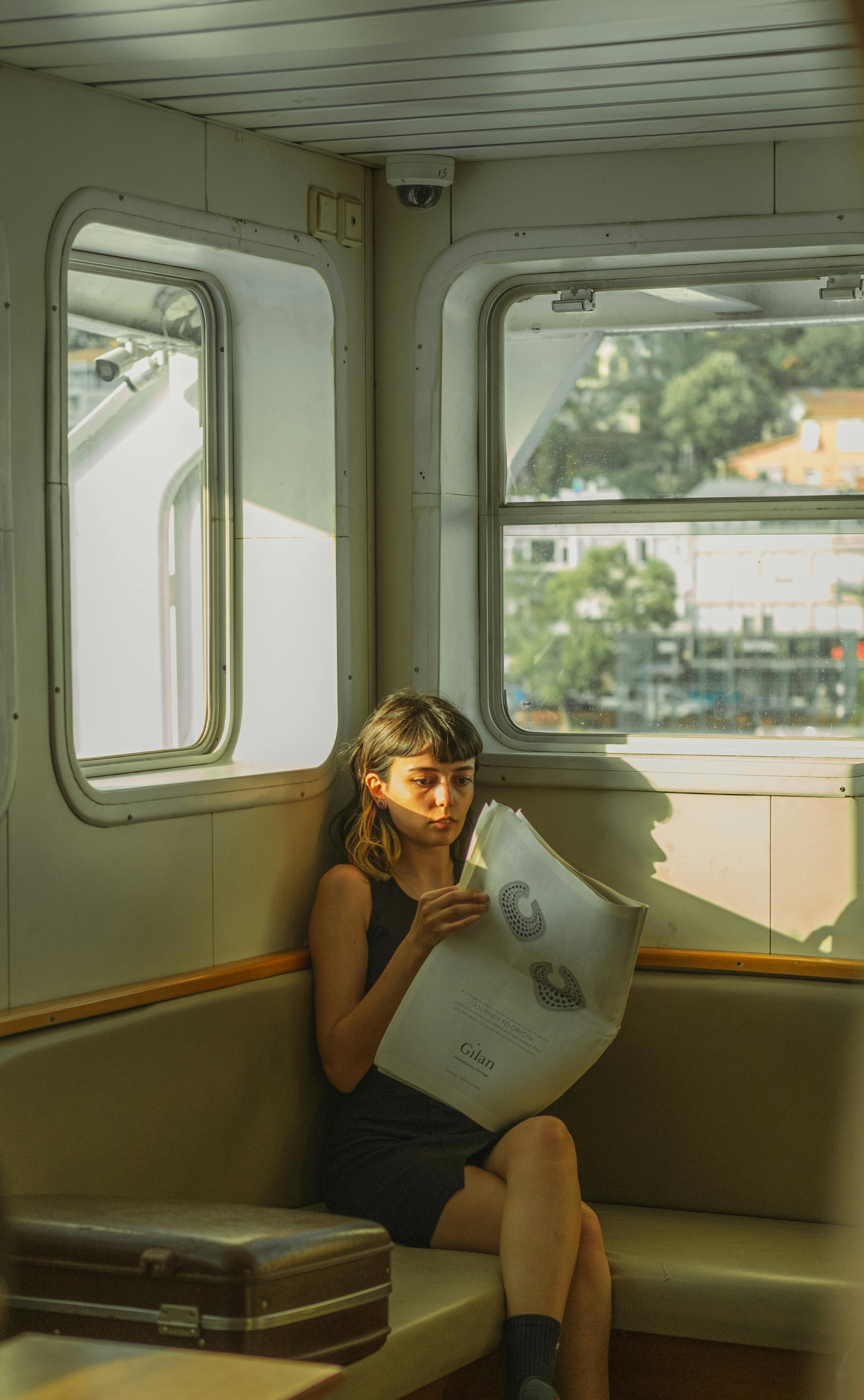 A woman enjoys reading a newspaper in a vintage ferry in Istanbul, Türkiye.