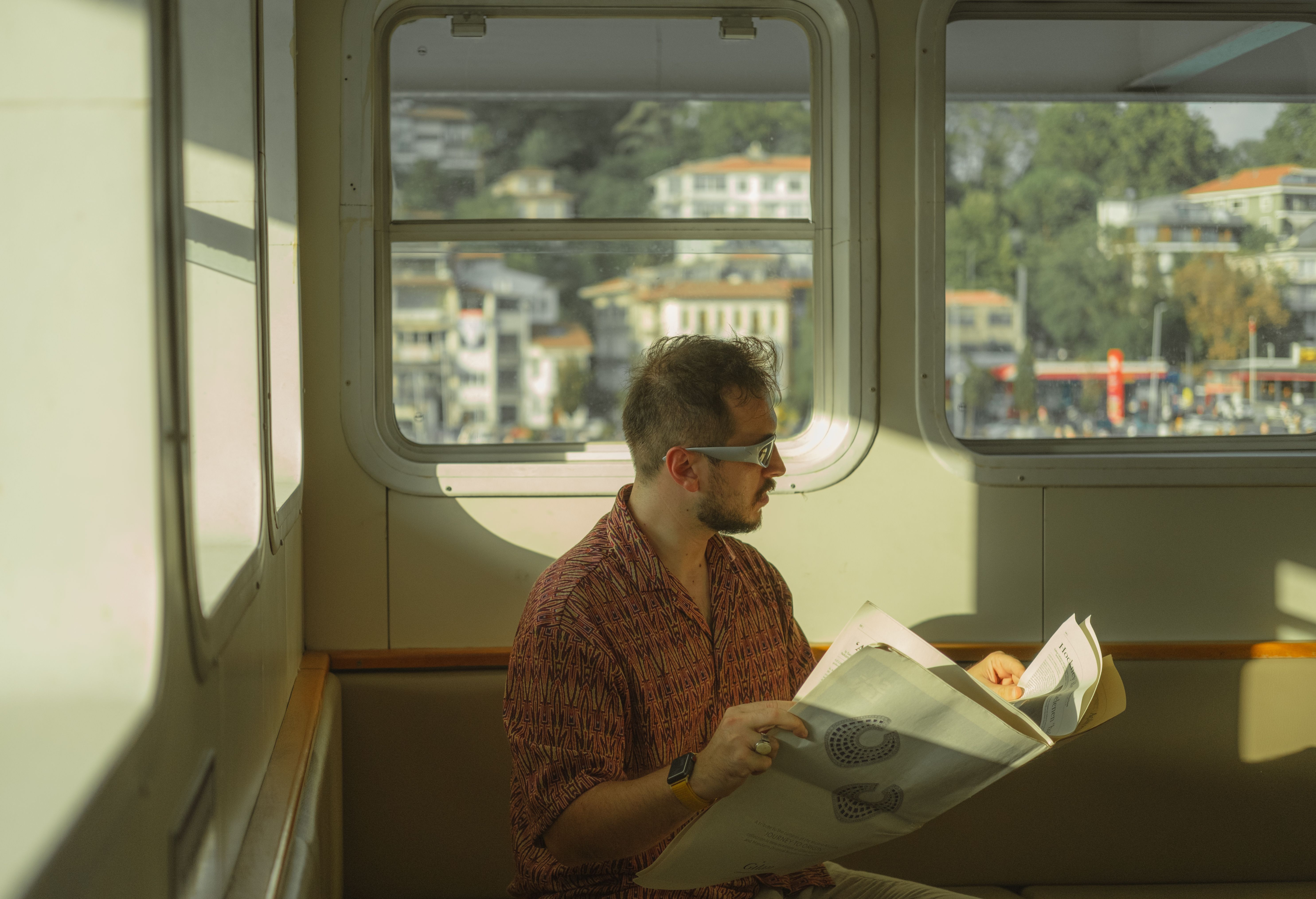 Meta Gözlüklerde Gizlilik Devrimi Başladı! - A man reads a newspaper while traveling on a ferry in İstanbul, offering a glimpse of local culture.