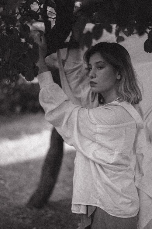 Free Artistic black and white portrait of a woman in nature holding tree branches. Stock Photo