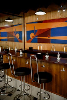 A contemporary bar interior featuring vibrant geometric artwork and sleek modern furniture.